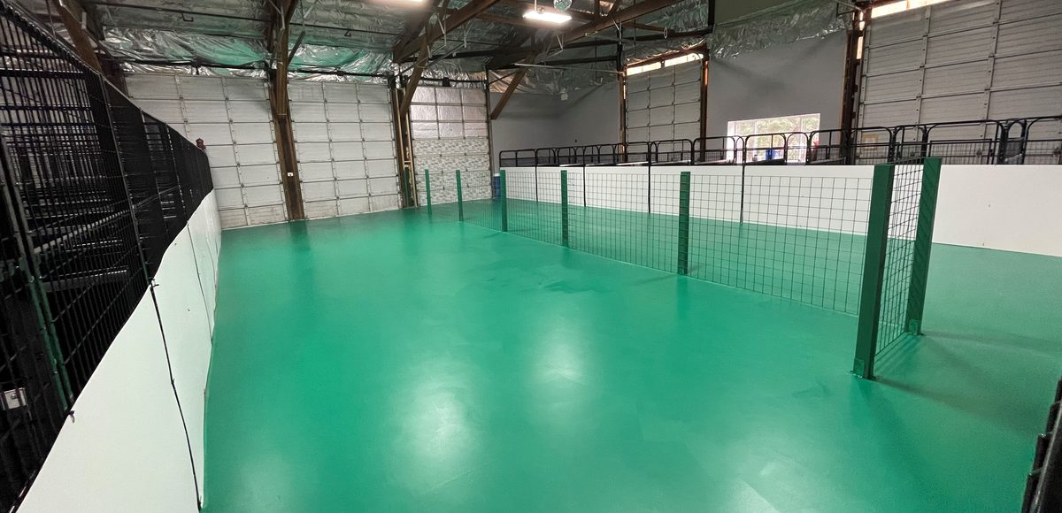 The Bark Yes! heated play warehouse with green floors and fenced play areas